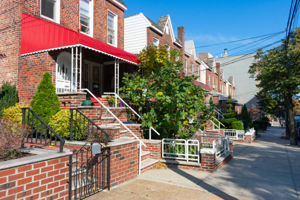 A Row of Old Brick Homes along the Sidewalk in Astoria Queens New York A row of old red brick homes with plants and trees along the sidewalk in Astoria Queens New York queens new york city stock pictures, royalty-free photos & images