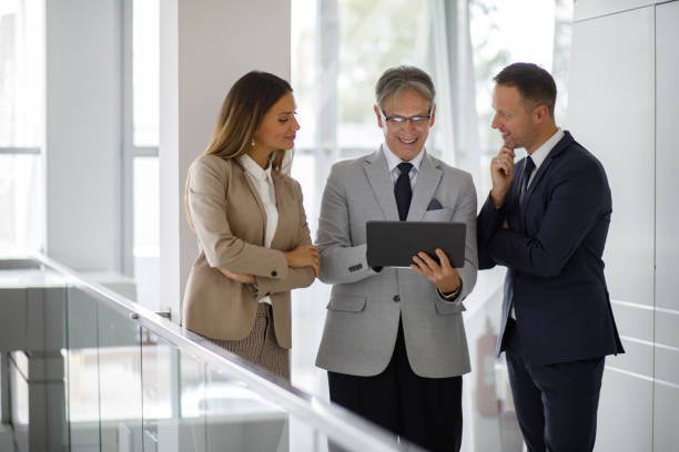 istock Group of mixed aged business people collaborating over digital tablet 1191895599