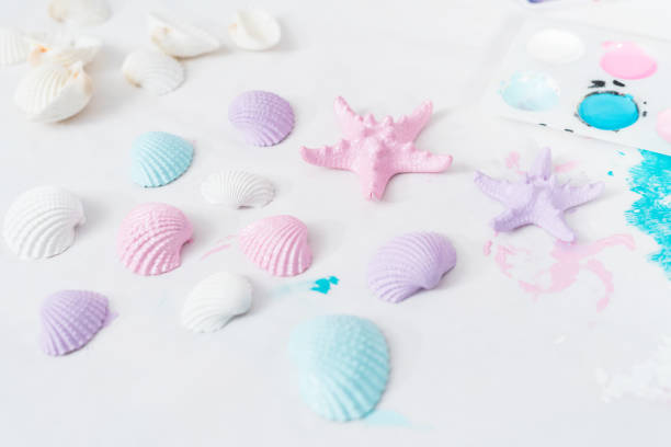 Painting seashells with acrylic paint for the mermaid kids craft project.