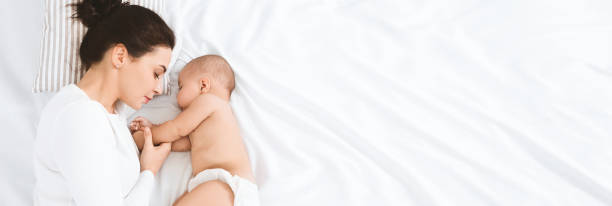joven mamá durmiendo con su bebé, panorama con espacio vacío - baby mother sleeping child fotografías e imágenes de stock