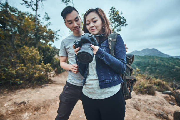 istock Asian couple are watching photos on camera 1191898070