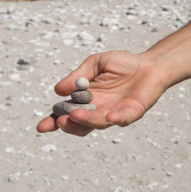 istock Stacked pebble stones in man's hand in sunny day 1191899617