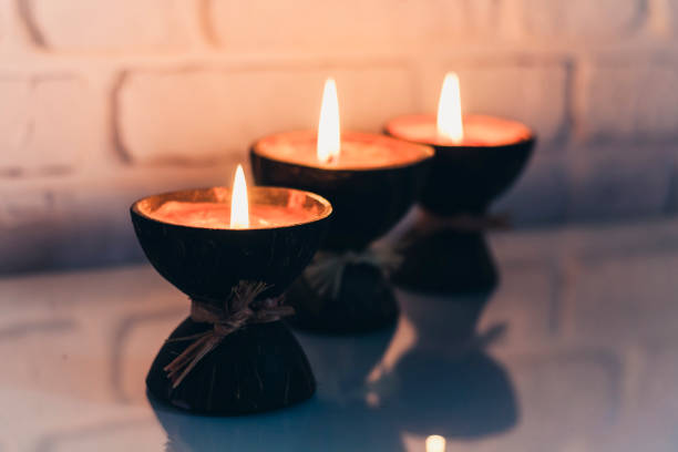 istock Burning spa aroma candles in coconut shell on a glass white table, cozy home interior 1191900300