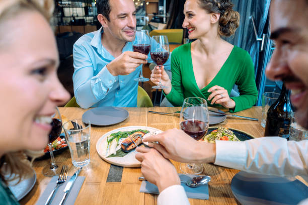 istock Two couples enjoying food and drink in a restaurant 1191903189