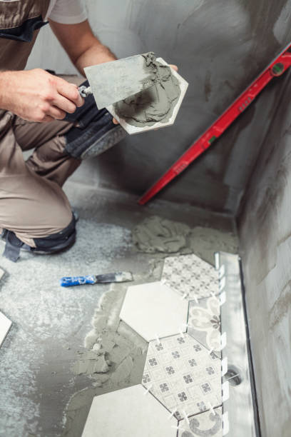 istock Tile worker laying tiles on the floor 1191903486