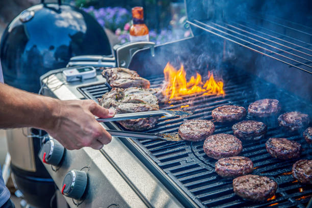 Marinated lamb joint and beef burgers cooking on a barbecue Marinated lamb joint and beef burgers cooking on an outdoor barbecue char grilled photos stock pictures, royalty-free photos & images