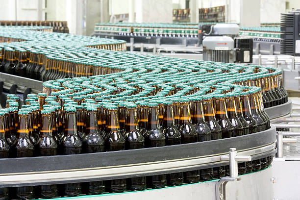 botellas de cerveza en cinta transportadora en fábrica - food and drink industry fotografías e imágenes de stock
