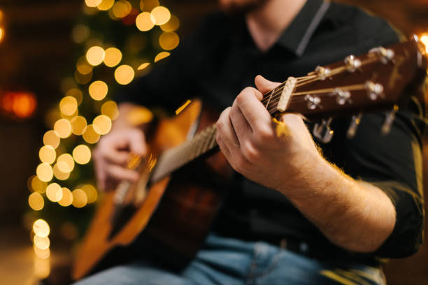 Male plays guitar close-up.