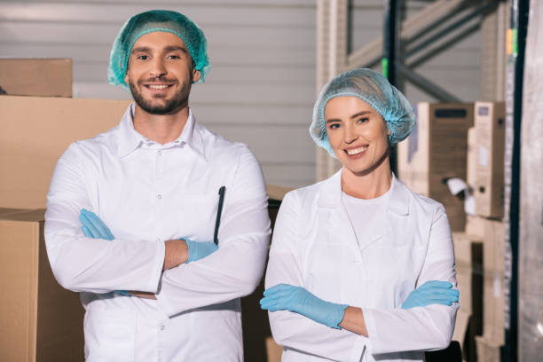 istock two cheerful storekeepers standing with crossed arms while smiling at camera 1191908883