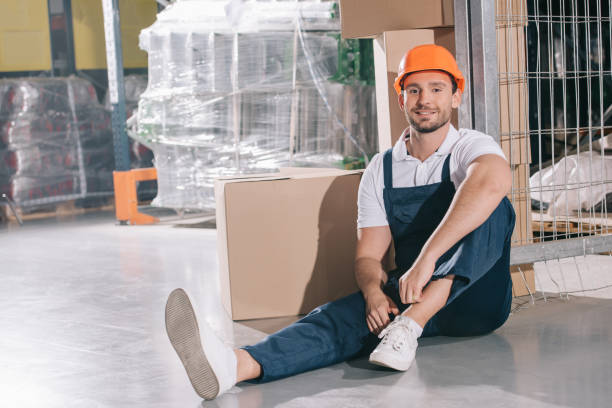 istock smiling loader sitting on floor near cardboard boxes and smiling at camera 1191908944