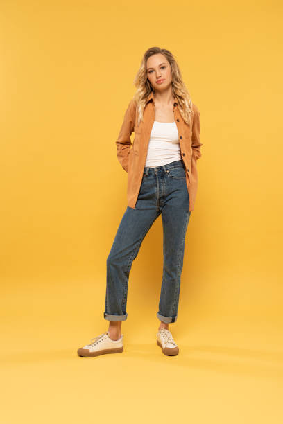 istock Attractive young woman looking at camera on yellow background 1191909067