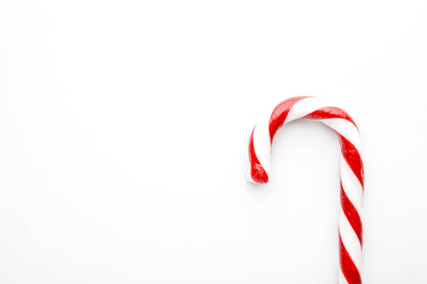 istock Christmas candy cane on white background. Minimal composition with peppermint candy. Flat lay, top view with space for text 1191910299