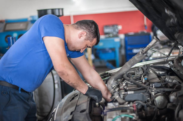 istock Car mechanic repairer service technician checks and repairs auto engine 1191912566