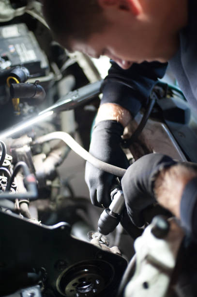 istock Car mechanic repairer service technician checks and repairs auto engine 1191915539