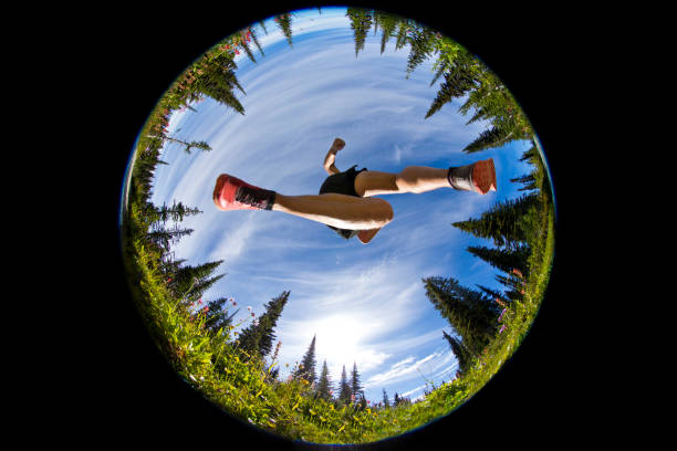 Trail Running Jump A man jumps while cross-country trail running near Revelstoke, British Columbia, Canada on a sunny summer day. He is wearing trail running shoes and running shorts. fish eye lens photos stock pictures, royalty-free photos & images