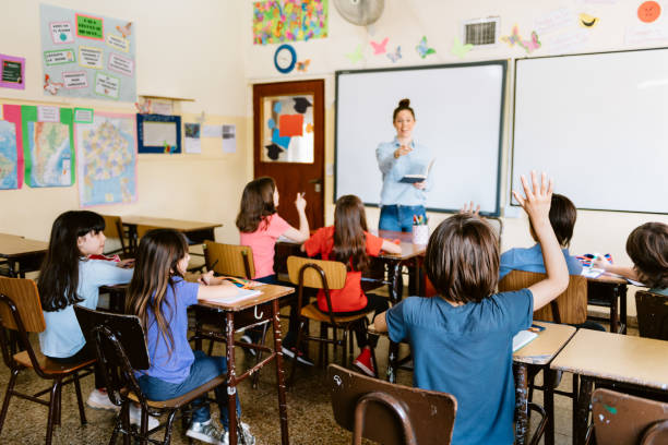 istock Primary School Teacher in Classroom with children 1191918161