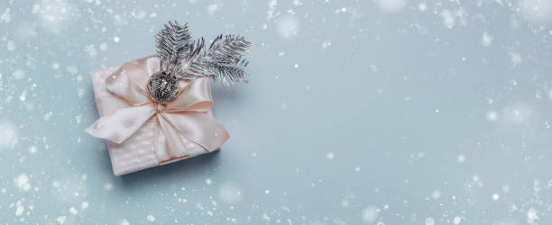 istock Christmas composition.Small gift box with Christmas decor, a spruce silver branch on a light blue background. Minimalism, flat lay. Banner 1191918234