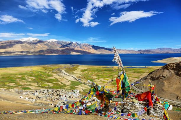 reflejo del lago tso moriri en el valle de rupshu con los picos chamser y lungser kangri de fondo en ladakh, india - many colored prayer flags fotografías e imágenes de stock
