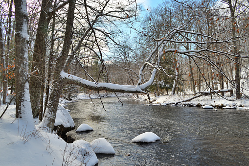 Wide shot of the first snow of the season on the Bantam River in Connecticut