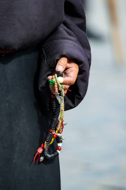 Hands of a Tibetan Buddhist with his prayer beads