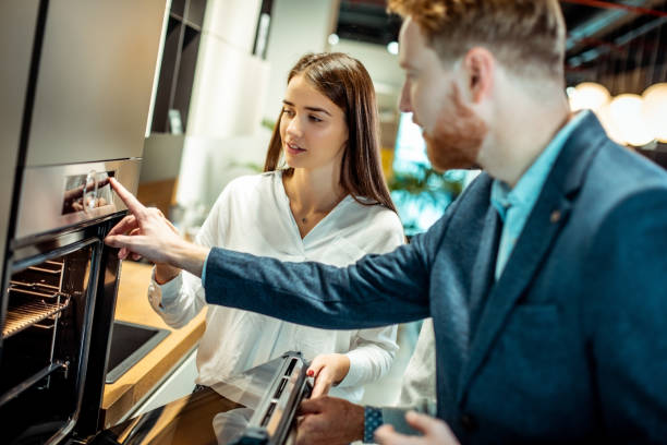 istock A shopkeeper helping a young female customer choose a modular kitchen oven in a kitchen appliances store 1191927398