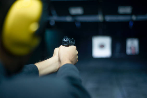 istock Rear view of unrecognizable young man shooting at the Shooting Range 1191927676