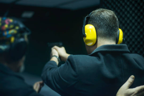 istock Unrecognizable instructor teaching how to shoot, giving briefing to young man at the shooting range 1191930758