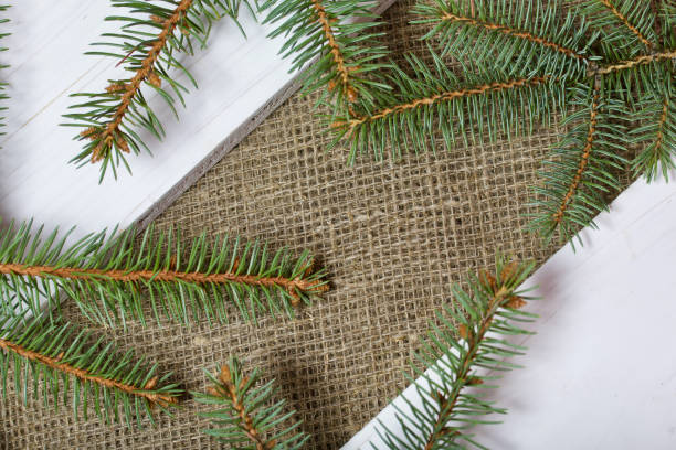 istock Fir branches and two white painted boards on a background of linen fabric. 1191931267