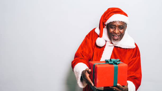 istock Santa Claus holding christmas gift on grey background 1191932645