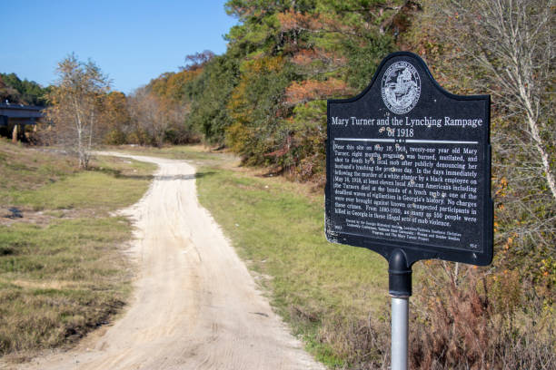 A bullet-riddled sign marks the spot near Hahira, Georgia, where Mary Turner was lynched in 1918. Hahira, Georgia - November 30, 2019: A bullet-riddled sign marks the spot where 21-year-old Mary Turner was brutally murdered in 1918 by a local mob after publicly denouncing her husband's lynching. 1918 stock pictures, royalty-free photos & images