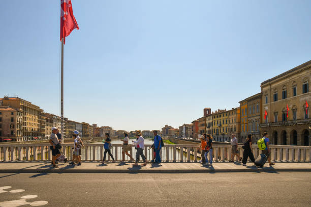 夏の観光客とピサの歴史的中心部のアルノ川のポンテ・ディ・メゾ橋からの街並み、トスカーナ、イタリア - ponte di mezzo ストックフォトと画像