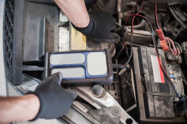 istock Car mechanic checking and testing automotive accumulator with battery tester 1191933534
