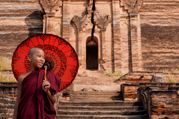 glücklicher novice buddhistischer mönch in den antiken ruinen der mingun-pagode in sagaing, mandalay, myanmar (birma) - parasol umbrella asian ethnicity asian culture stock-fotos und bilder