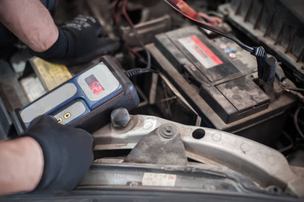 istock Car mechanic checking and testing automotive accumulator with battery tester 1191933787