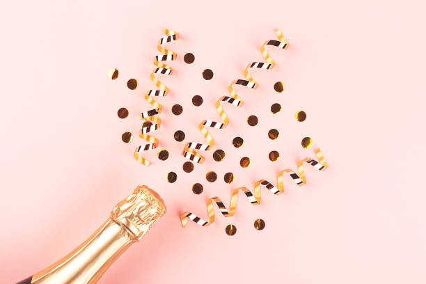 istock Creative New Year composition with champagne bottle and confetti on pastel pink background. 1191935609