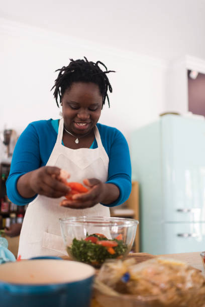 istock Front view of a smiling woman preparing vegetables in her kitchen 1191937387