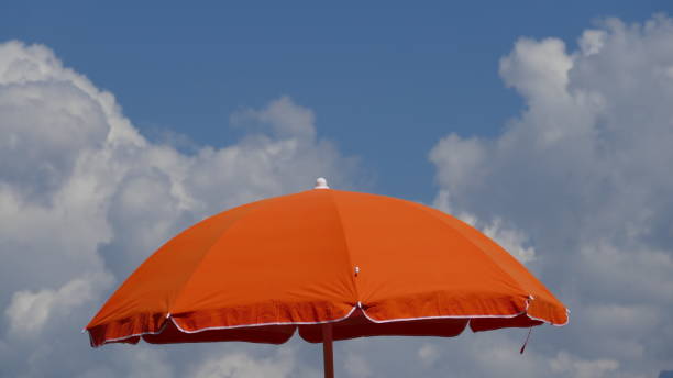 Orange Parasol against a blue cloudy sky.