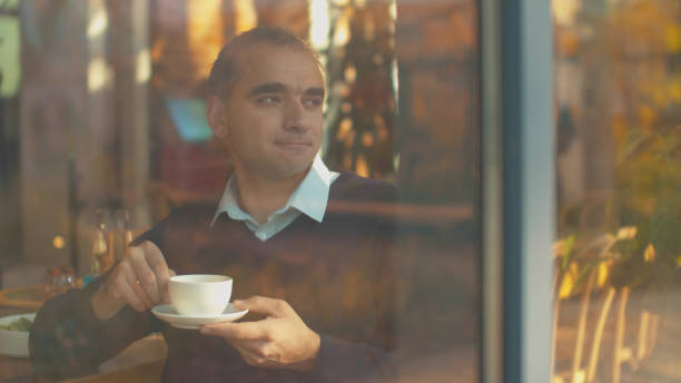istock Man drinks tea and looks out the window with joy 1191945451