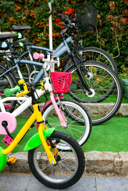 Two abandoned old children's bikes on the side of a road.