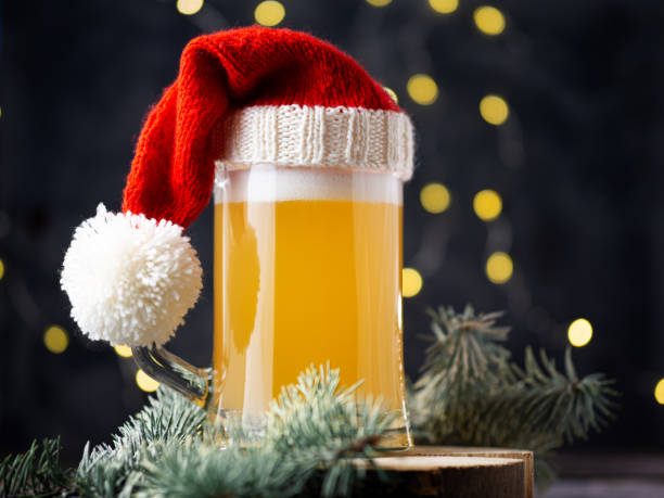 istock Beer mug in Santa's Christmas hat on dark background with copyspace 1191952389