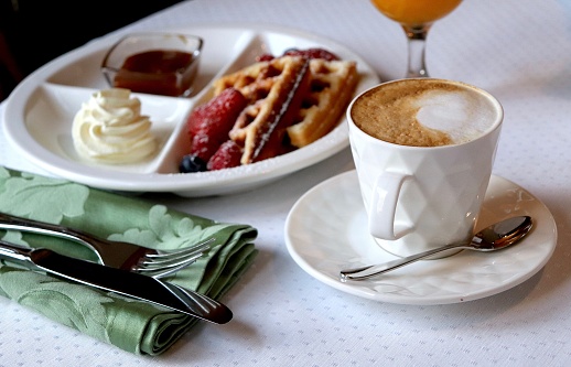Breakfast in the cafe. Vienna waffles, cup of coffee, berries and chocolate