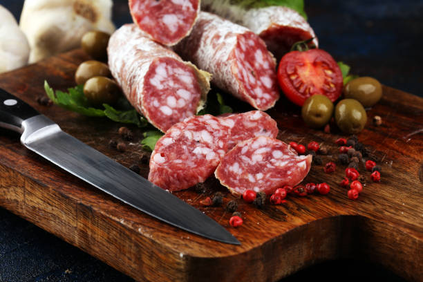 istock thinly sliced salami on a wooden texture on the background. 1191958091