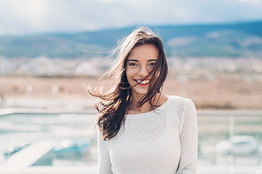 Smiling young woman outdoors in the sun