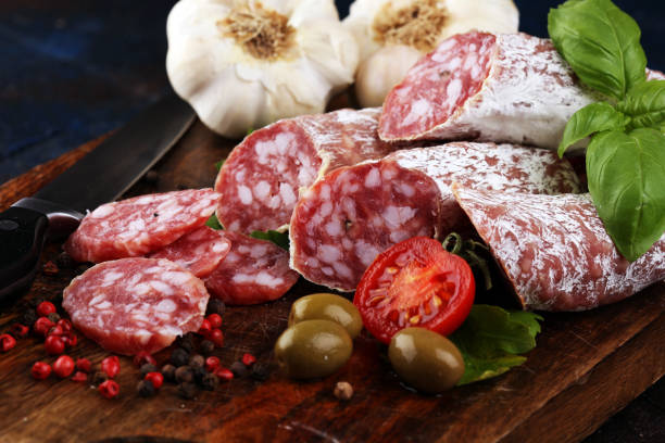 istock thinly sliced salami on a wooden texture on the background. 1191960766