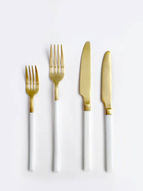 White golden cutlery view from above on a white background. Top view.Knife and fork for a festive table for a wedding, birthday or party.