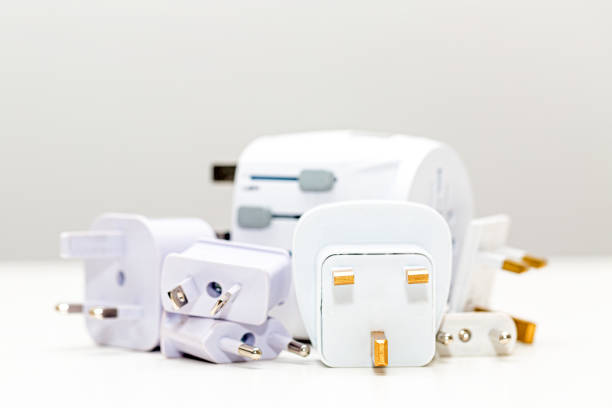 Pile of various international travel power plug adapters in different types and sizes