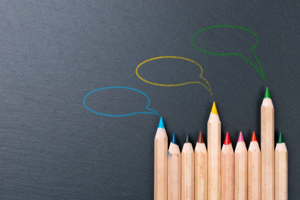 istock Colored pencils with three speech bubbles above. Chalkboard background, copy space 1191963653