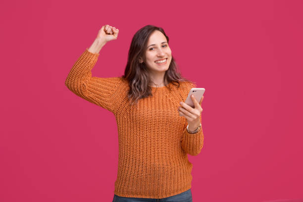 istock Happy beautiful woman using smartphone and celebrate victory 1191965873