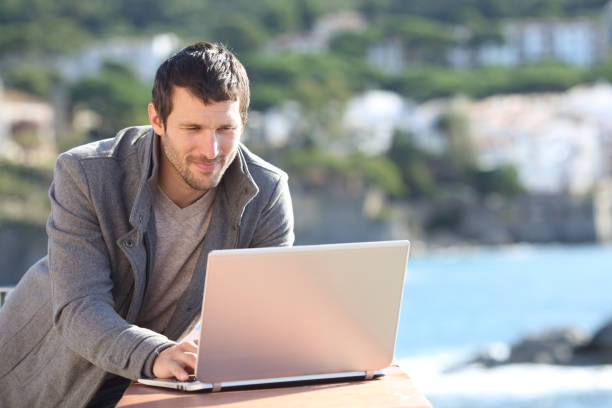 istock Serious man using a laptop in a balcony in winter 1191966382