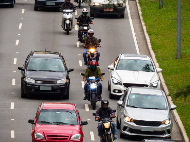 istock motorcycles riding between cars on large avenue 1191967049